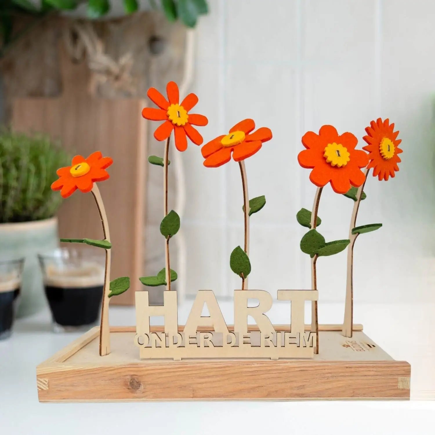 Vilten bloemen van Happy Blooms in het oranje met bordje 'hart onder de riem'. 